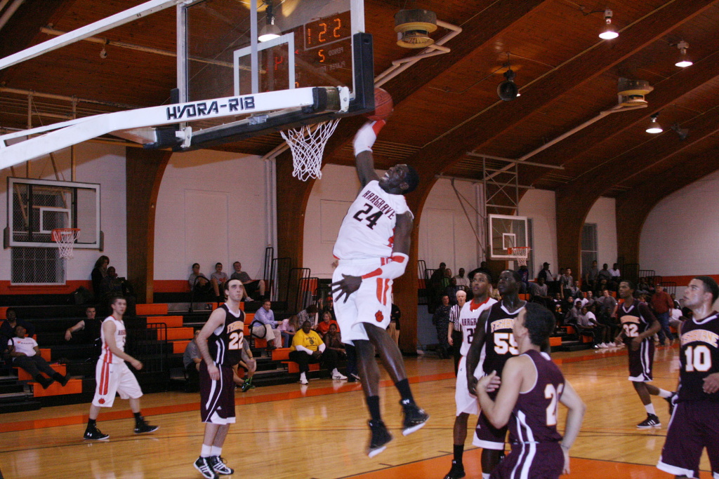 Harrell charges the basketball