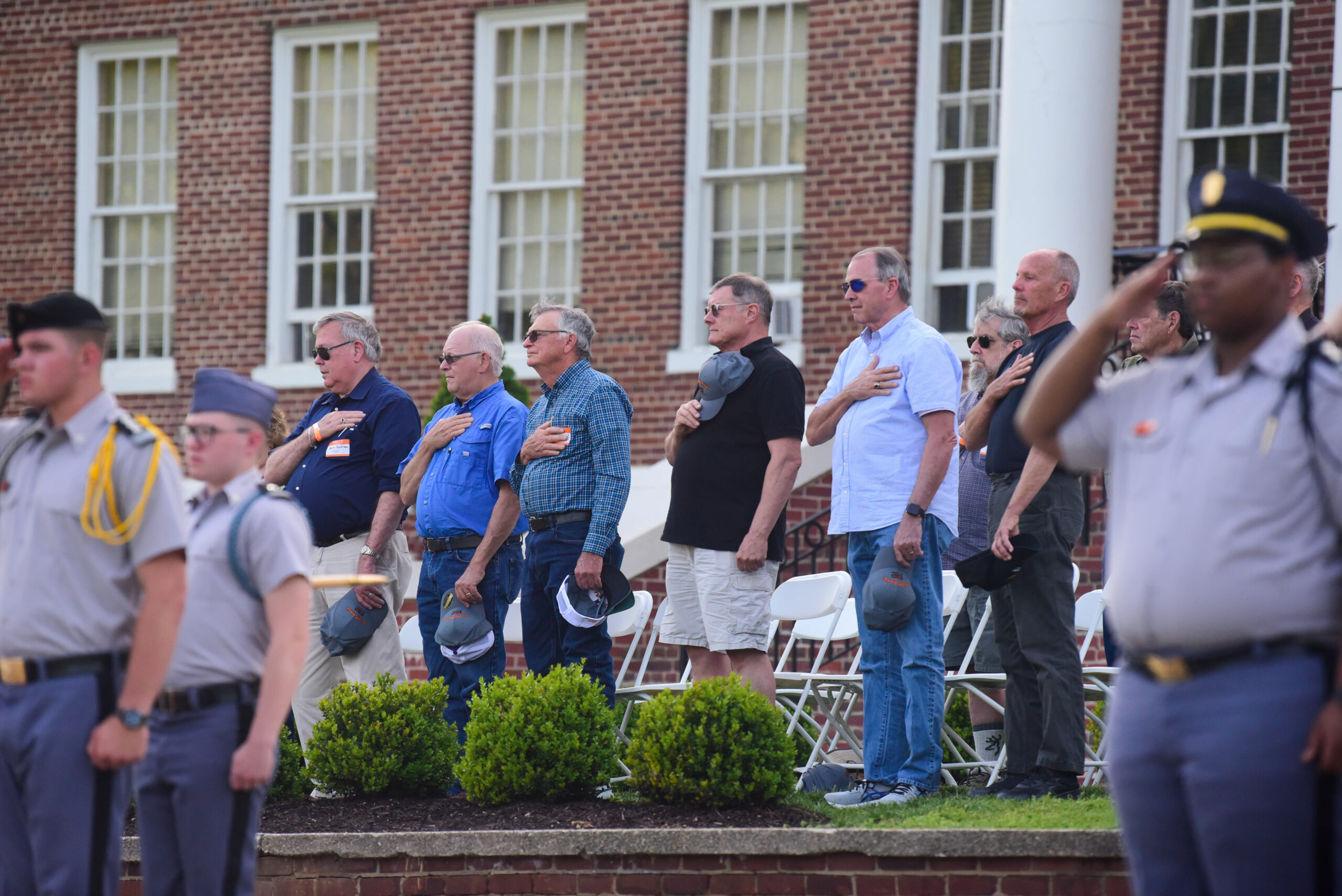 Group of Alumni with their hands on their hearts during a retreat ceremony.