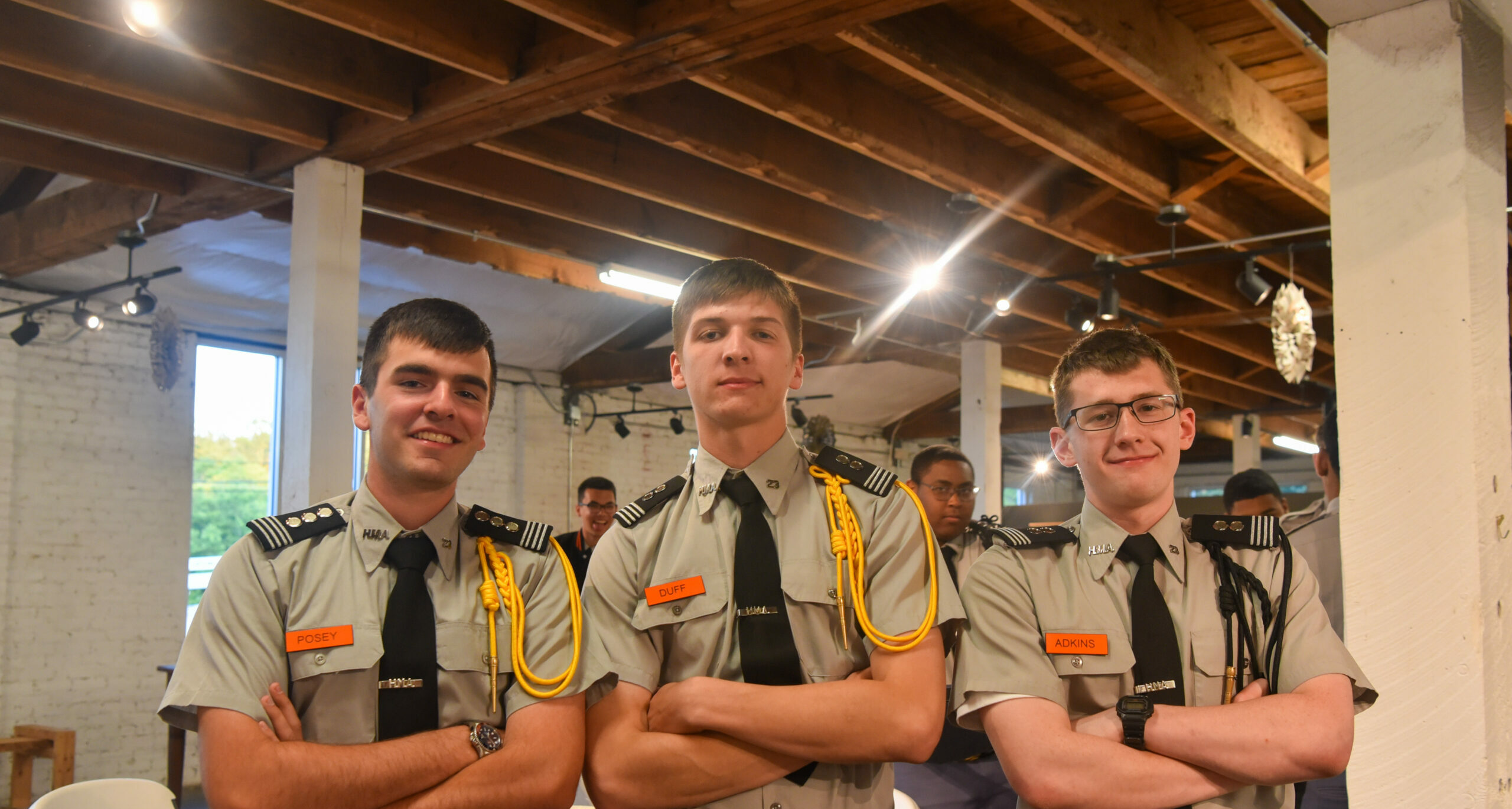 Three cadets standing smiling at the viewer.