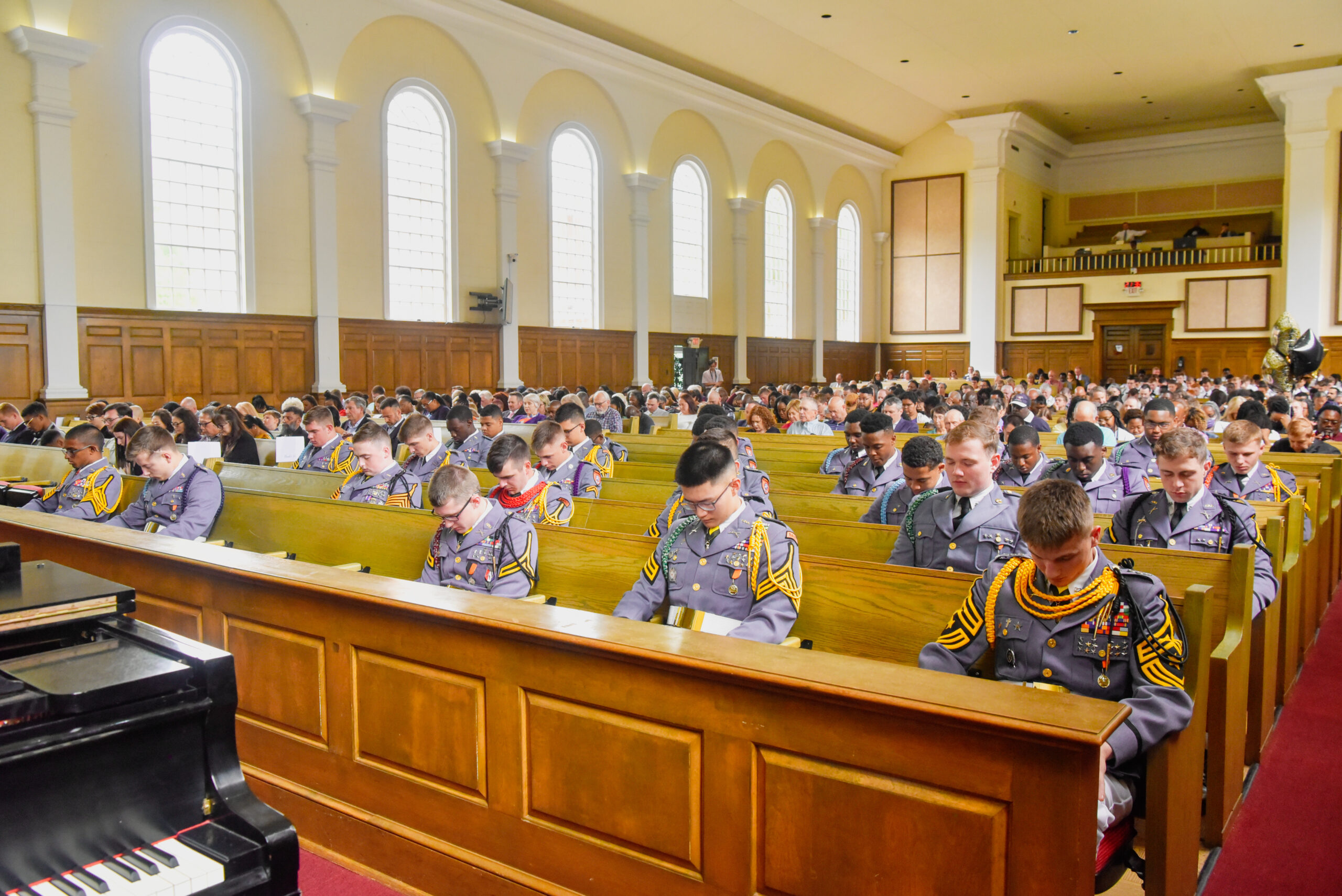 Cadets in chapel bowing their heads in prayer.
