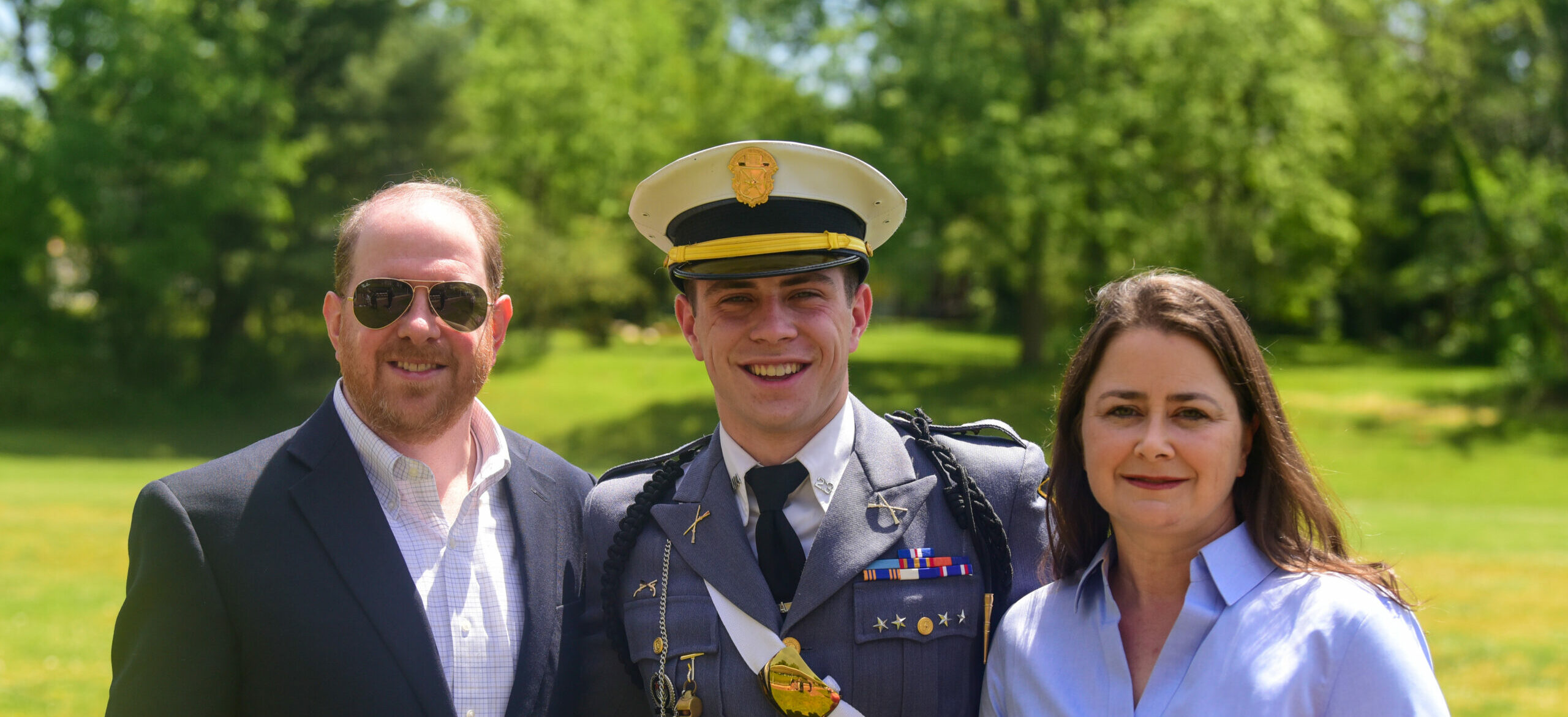 Cadet with his parents smiling at the viewer